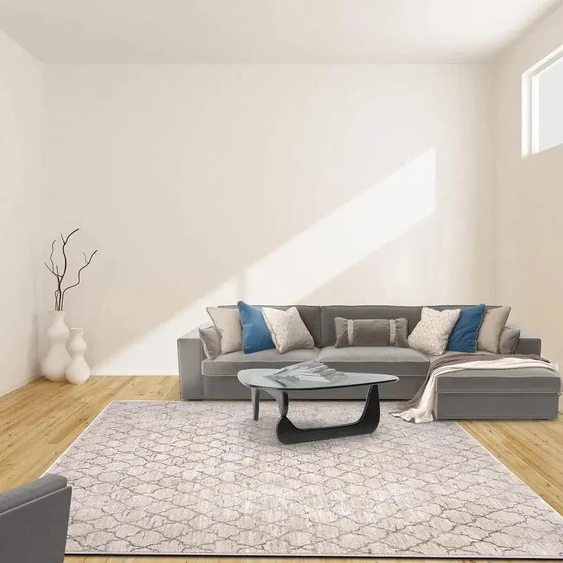 Modern living room with a gray sectional sofa, coffee table, and decorative pillows.